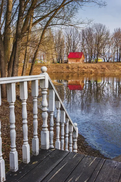 stock image Railing with balusters on the background of a wooden cottage