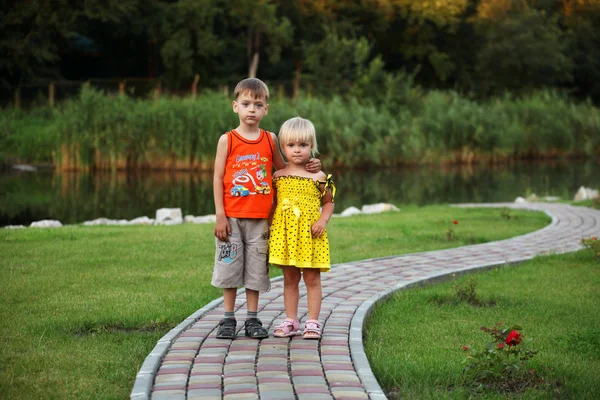 Dvě děti (chlapec a dívka) na procházce v parku v létě — Stock fotografie