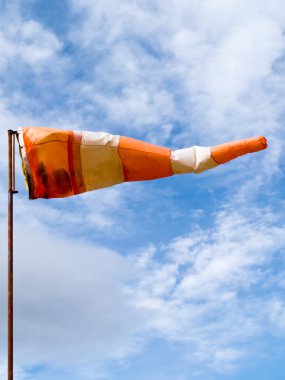 Full wind cone weather vane on windy day clipart