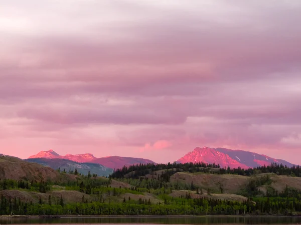 Gün batımı ışıkta parlayan uzak yukon dağlar — Stok fotoğraf