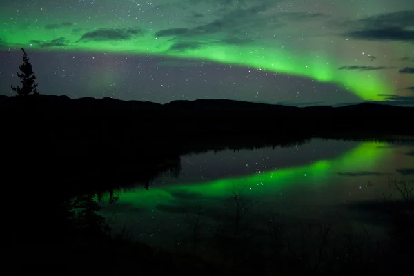 Nachtelijke hemel sterren wolken noordelijke lichten gespiegeld — Stockfoto