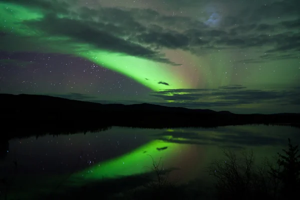 Звезды ночного неба отражали северное сияние — стоковое фото