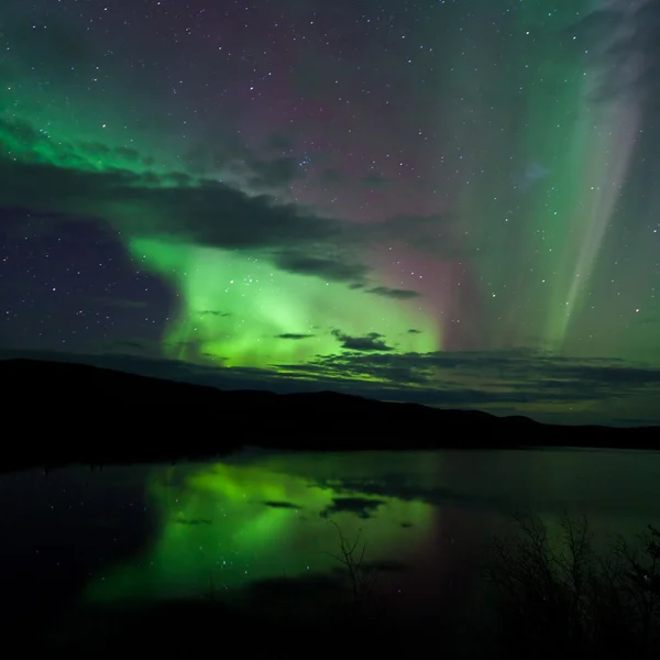 Nachtelijke hemel sterren wolken noordelijke lichten gespiegeld — Stockfoto