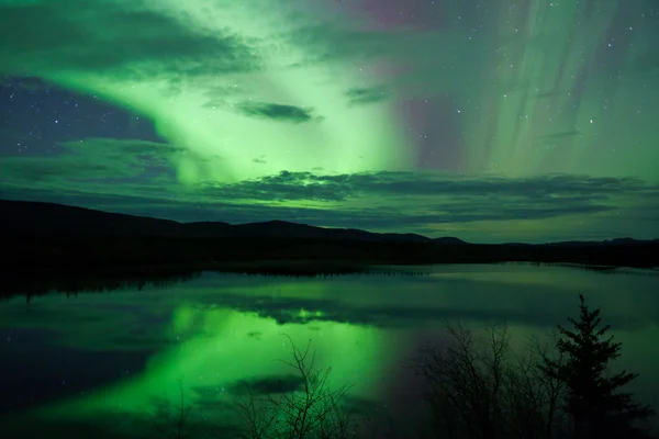 Nachtelijke hemel sterren wolken noordelijke lichten gespiegeld — Stockfoto
