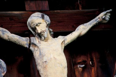 Weathered Jesus Christ figure nailed to the cross clipart