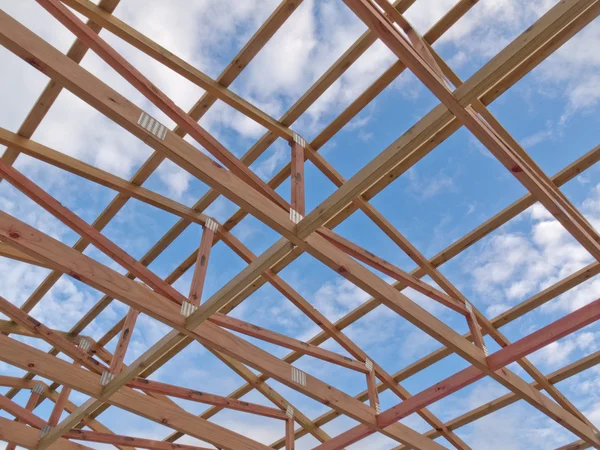 Roof frame construction under cloudy blue sky — Stockfoto