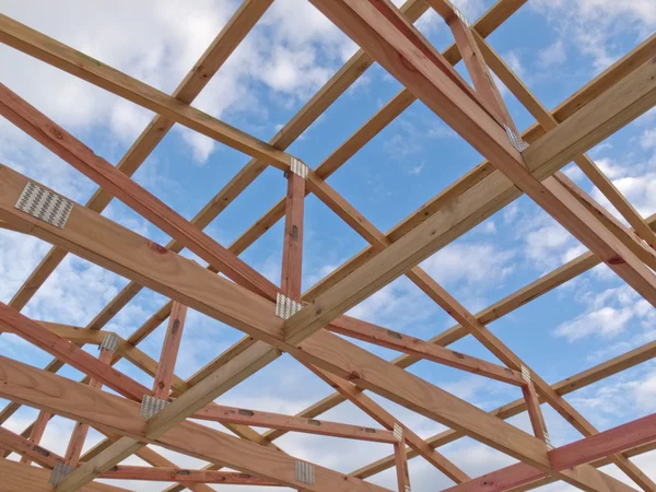 Roof frame construction under cloudy blue sky — Stockfoto