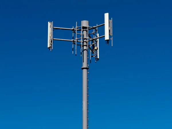 Антенны мобильных телефонов на металлической башне на голубом небе — стоковое фото