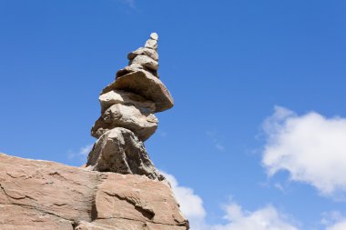 Rock cairn iz işareti mavi gökyüzü ile kaya üzerinde