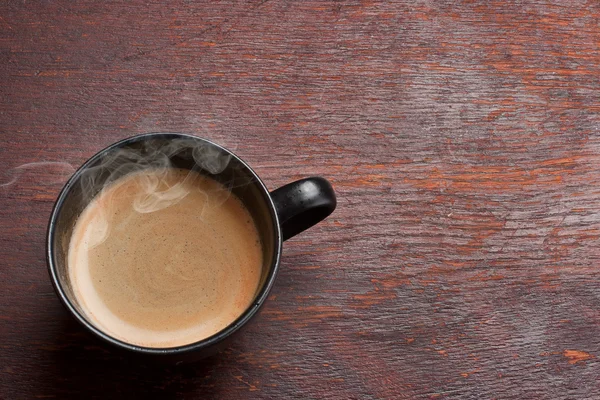 Zwarte koffie beker over grunge houten tafel — Stockfoto