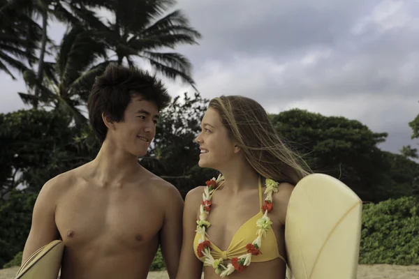 Genç bir çift onların surf Komiteler ile sahilde — Stok fotoğraf