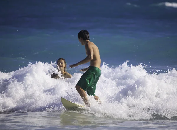 Молода пара, що серфінгує на Гаваях — стокове фото