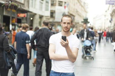 Young Man in City with mobile phone clipart