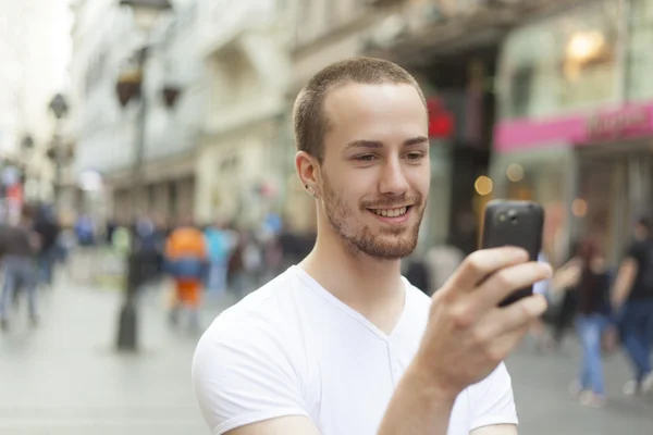 Mladý muž s pohybovými mobilní telefon — Stock fotografie
