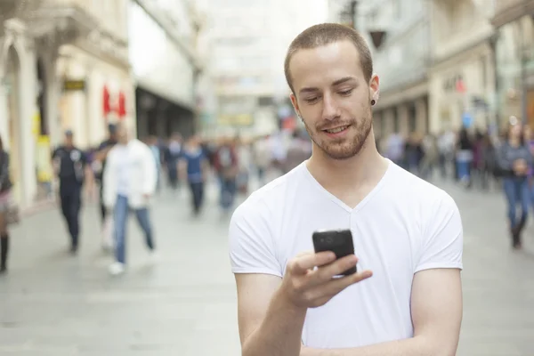 Young Man with cell phone walking Royalty Free Stock Images
