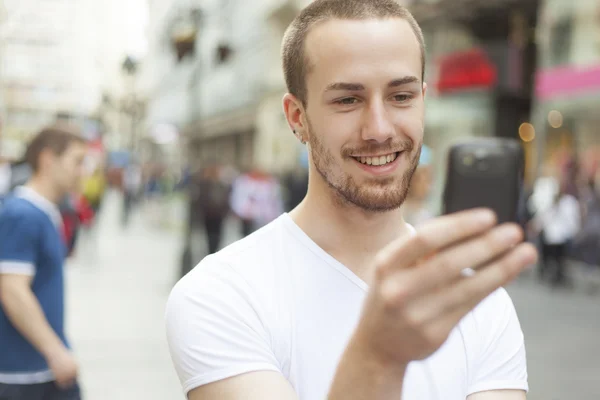 Hombre joven con teléfono celular caminando Imágenes de stock libres de derechos