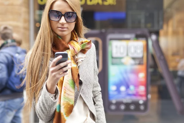智能手机走在大街上与年轻时尚女人 — 图库照片