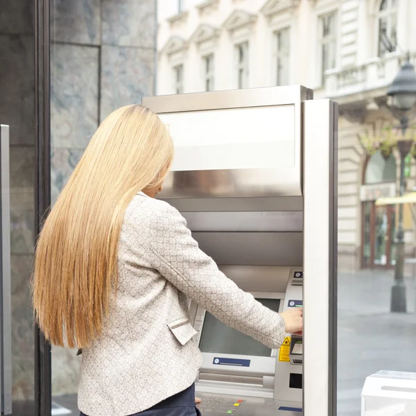 Жінка використання банкомат банку — стокове фото