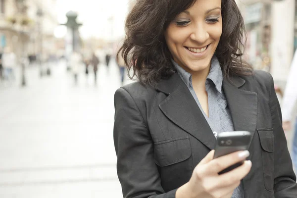 Junge Geschäftsfrau mit Smartphone in der Stadt unterwegs — Stockfoto