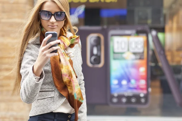 Жінка на вулиці зі смартфоном — стокове фото