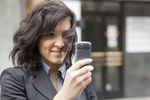 Молодая женщина фотографирует с помощью мобильного телефона — стоковое фото