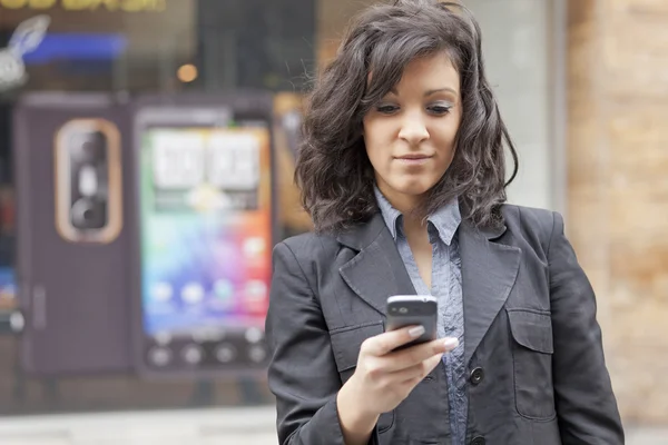 Vrouw met mobiele telefoon wandelen — Stockfoto