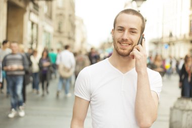 Man with mobile phone walking on street clipart