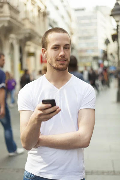 Jeune homme avec téléphone portable marche — Photo