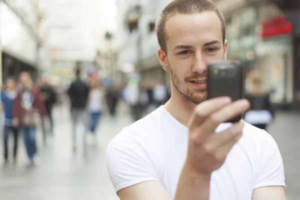 Jonge man met mobiele telefoon wandelen — Stockfoto