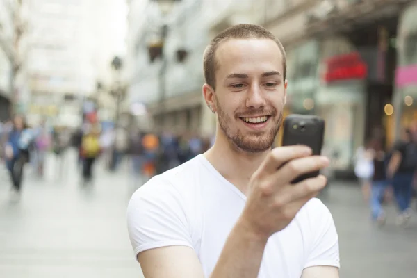 Jonge man met mobiele telefoon wandelen — Stockfoto