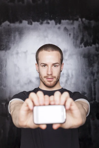 Man showing screen of smartphone, focus on head — Stock Photo, Image