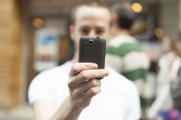 Hombres en la calle fotografiando con teléfono inteligente —  Fotos de Stock