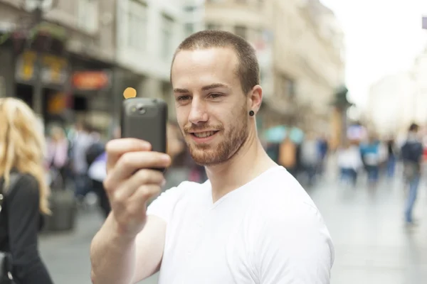 Faceci na ulicy fotografujący telefonem komórkowym — Zdjęcie stockowe