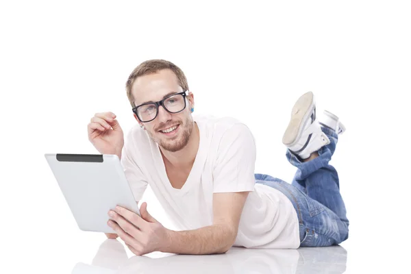 Slimme nerd man met tablet PC liggend op de vloer — Stockfoto