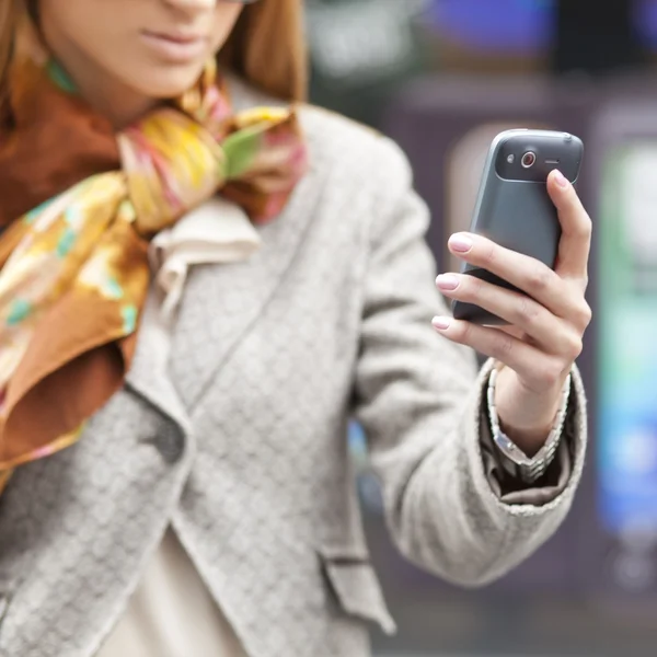 Dames hand met mobiele telefoon — Stockfoto