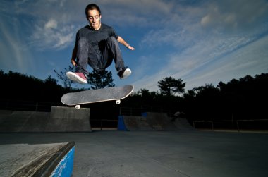 Skateboarder on a flip trick clipart