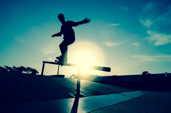 Silhouette skateboarder su una macina — Foto Stock