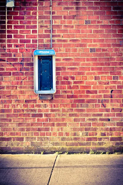 Τοίχο από τούβλα με τηλεφωνικό θάλαμο — Φωτογραφία Αρχείου