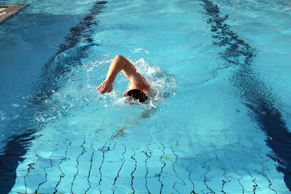 Человек учится плавать в воде — стоковое фото