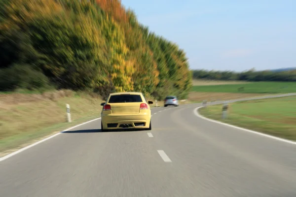 Ασημένιο και κίτρινο αυτοκίνητο οδήγηση στο δρόμο — Φωτογραφία Αρχείου