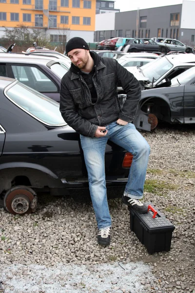 Hombre atornillado piezas de automóviles de coches viejos — Foto de Stock