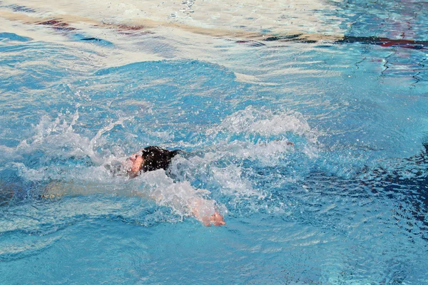 Ung man simma ryggsim i vatten — Stockfoto