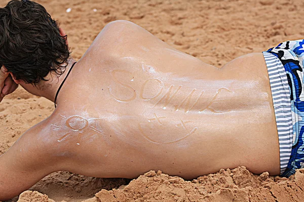 Человек, нарисованный на пляже солнцезащитным кремом — стоковое фото
