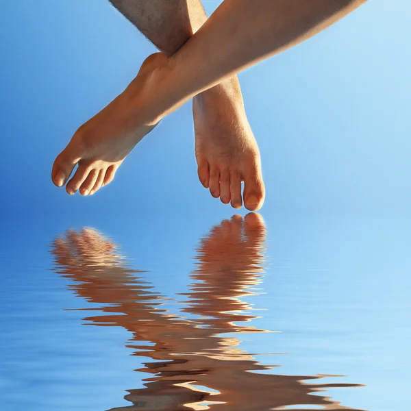 Feminino e masculino pé em água azul — Fotografia de Stock