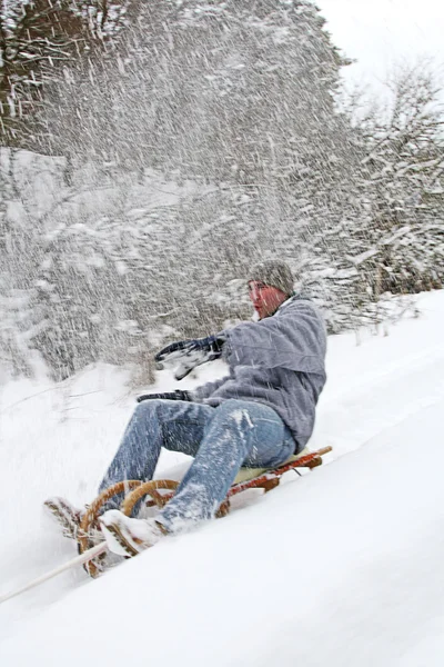 Mladý muž jde na saních v zimě — Stock fotografie
