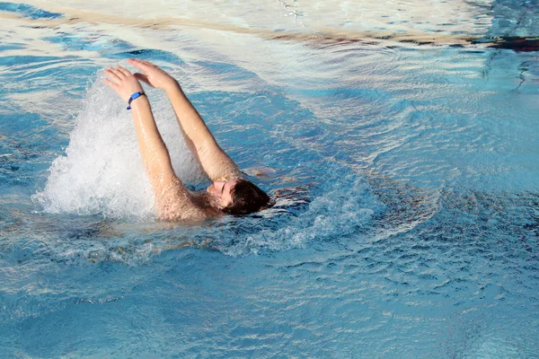 Young man swimming backstroke in pool — Stock Photo, Image