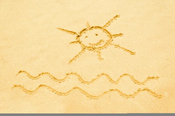 Smiling sun drawn on a sandy beach — Stock Photo, Image