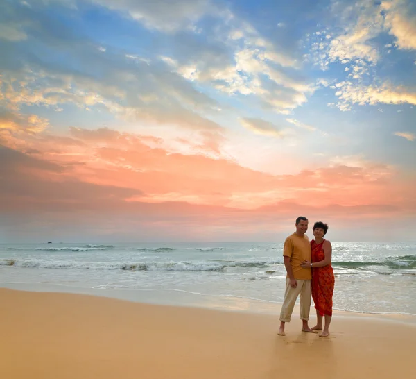 Couple sur la plage au coucher du soleil — Photo