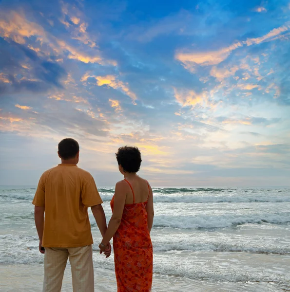 Couple sur la plage au coucher du soleil — Photo