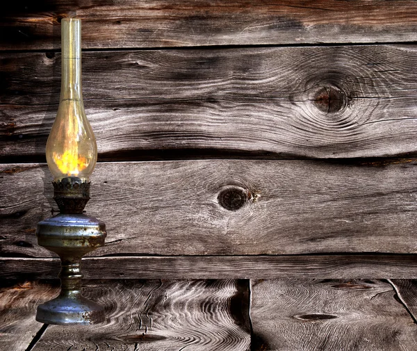 Stock image Old rusty lamp against dark wooden boards